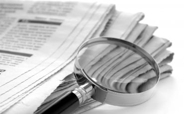 newspaper and a magnifying glass