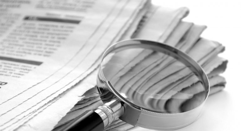newspaper and a magnifying glass